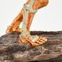 Close-up shot of the DOOM Eternal Revenant Statue, showing the details of the legs and feet with their cybernetic enhancements and rotting flesh, as well as the boulder beneath them.