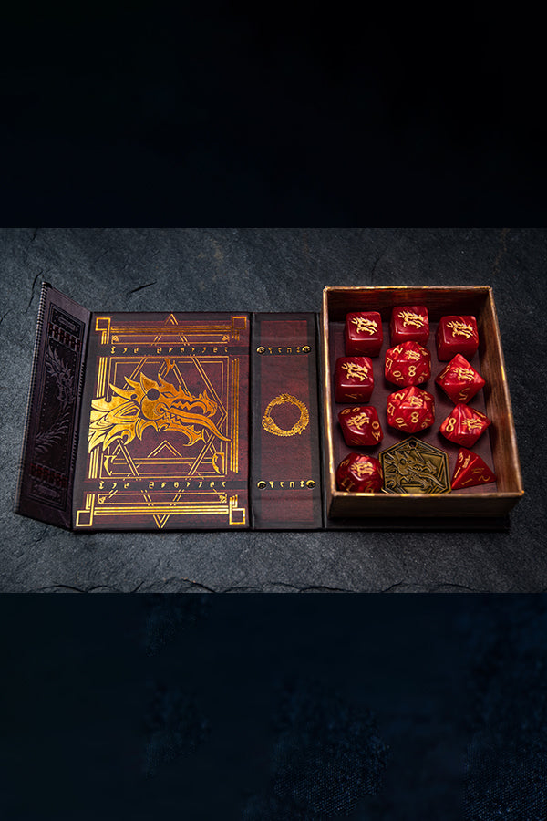 The dice set inside its open box. This purple-red box features gold foil artwork feat. the Ebonheart dragon head, the game’s three-headed Ouroboros, and dragon tongue writing.