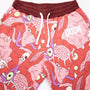 Detail shot of the upper part of the DOOM Meat Sweats, showing the details of the artwork, the ribbed burgundy waistband with flat dawcords and the DOOM logo appliqué on the left hip.